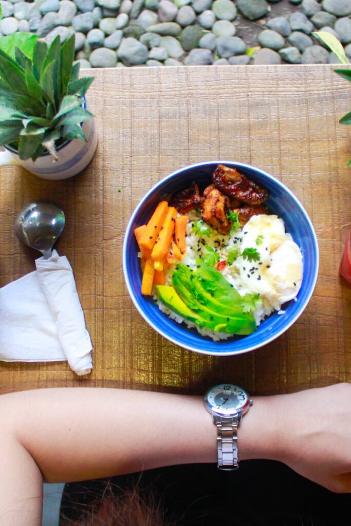 Fresh and healthy bowl meal with juice and smartphone on a wooden table, perfect for lifestyle and food photography.